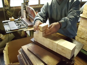 Uniformly cut hinoki pieces are neatly piled on each other to prepare them for the joint cutting